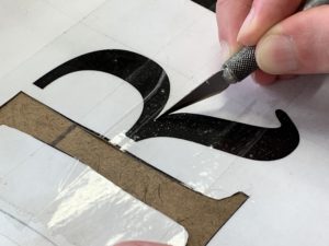 Cutting letters out for a stencil using a hobby knife or X-Acto knife - How To Holiday