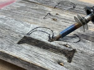 Burning letters on a wood halloween tombstone with a woodburner - How To Holiday