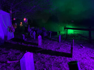 Halloween 2020 - Cemetery with corpse and tombstones under purple light and green background light