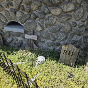 Tombstone Trio in front of a stone wall for Halloween