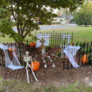 Tombstone Trio in Halloween cemetery with pumpkins and skeletons