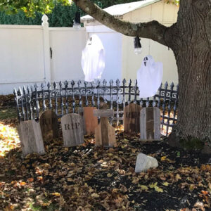 Wood tombstones in Halloween cemetery with hanging ghosts