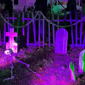 Wood tombstones in a Halloween cemetery with purple and green lights